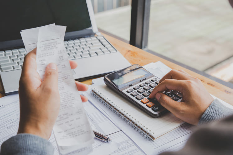young-man-using-calculator-calculate-bills-home-office (1)